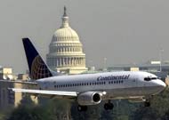 A Continental Airlines jet passes in front of the U.S. Capitol as Reagan National Airport reopens